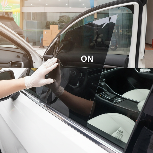 Technician carefully applies a clear NanoTint Auto SPD Smart Film Kit to a luxury car's front passenger window.