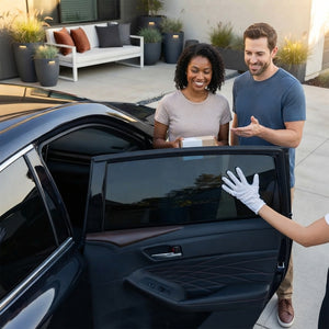 A diverse couple standing by a modern car with premium dark window tint, highlighting a clean and professional automotive ins